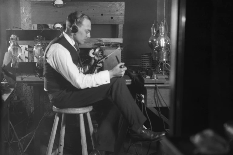 Frank Conrad sits with his broadcast equipment.