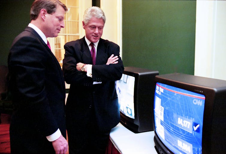 Al Gore and Bill Clinton watch TV