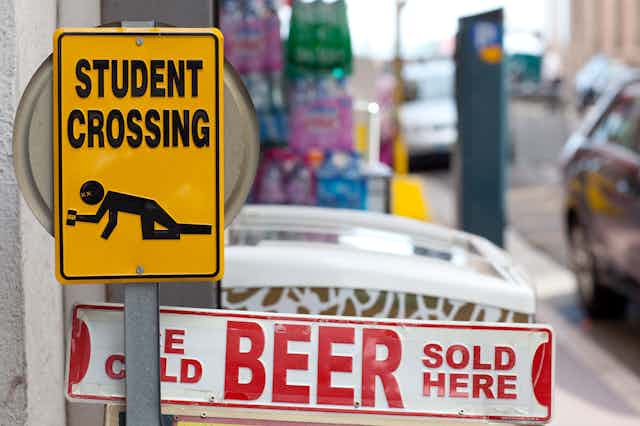 'Student crossing' sign showing person crawling with beer can in hand