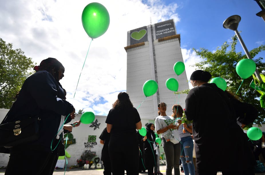 People with green balloons outside Grenfell Tower.