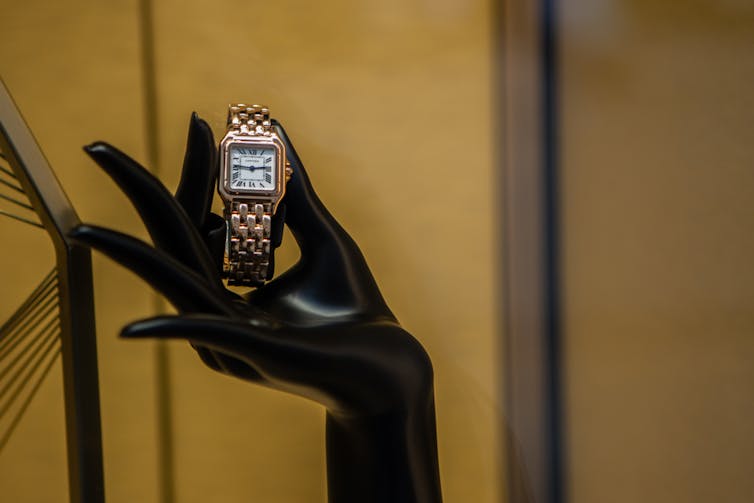 Hand holding up Cartier watch