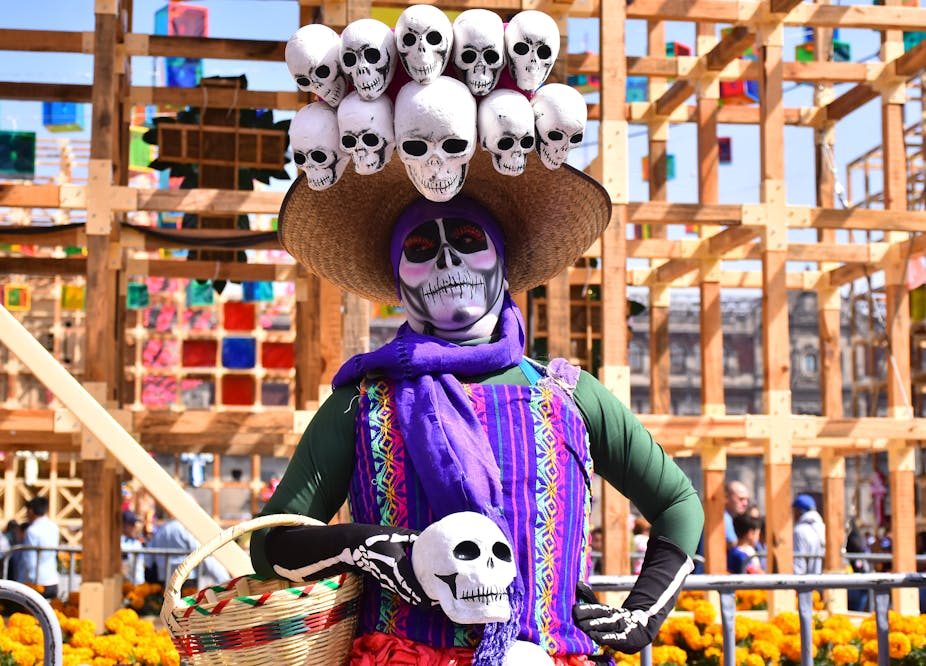 Una mujer con el rostro pintado como un esqueleto participa en las celebraciones del Día de Muertos en la Ciudad de México