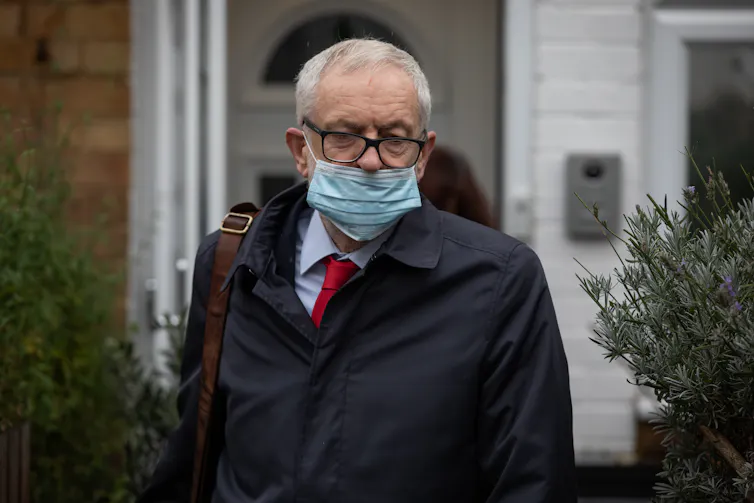 Jeremy Corbyn wearing a covid mask over his mouth.