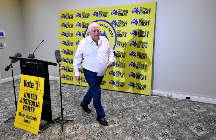 Clive Palmer walks away from a press conference.