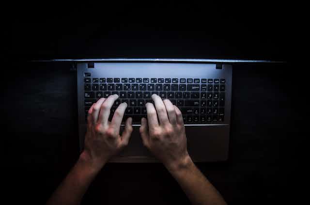 Hands on a keyboard with a dark background