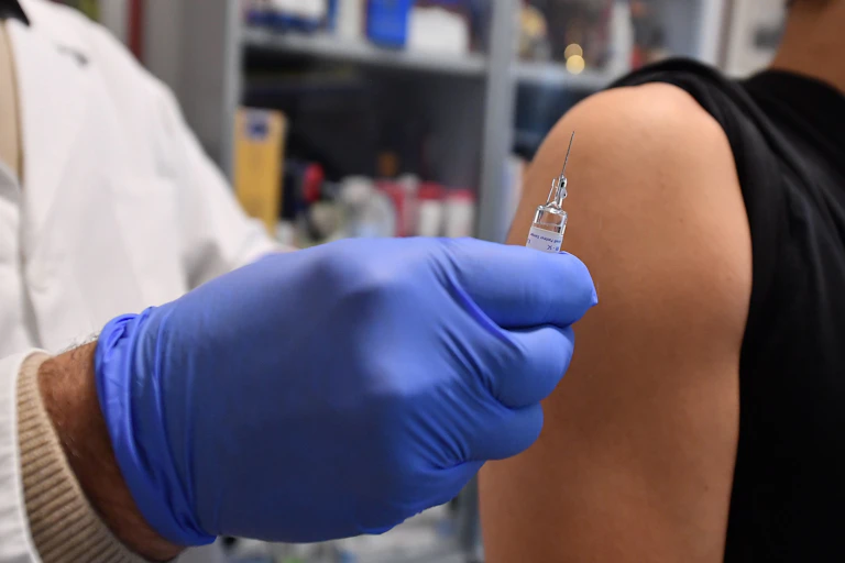 A person being given a vaccine by a health-care worker