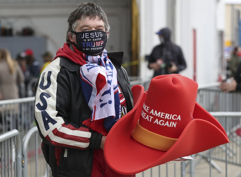 Man holding large Make America Great Again hat