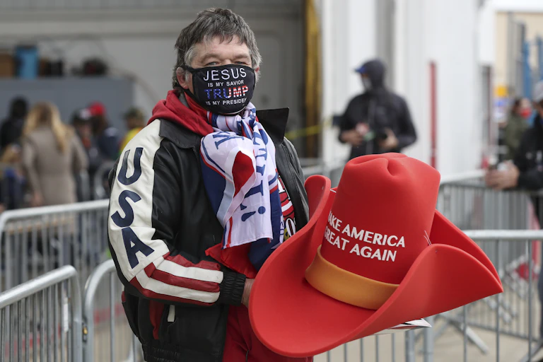 Man holding large Make America Great Again hat