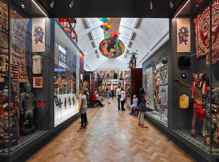People wander through a grand museum exhibit.