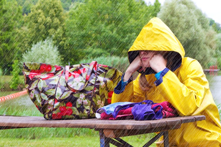 Image of a woman sitting in the rain.