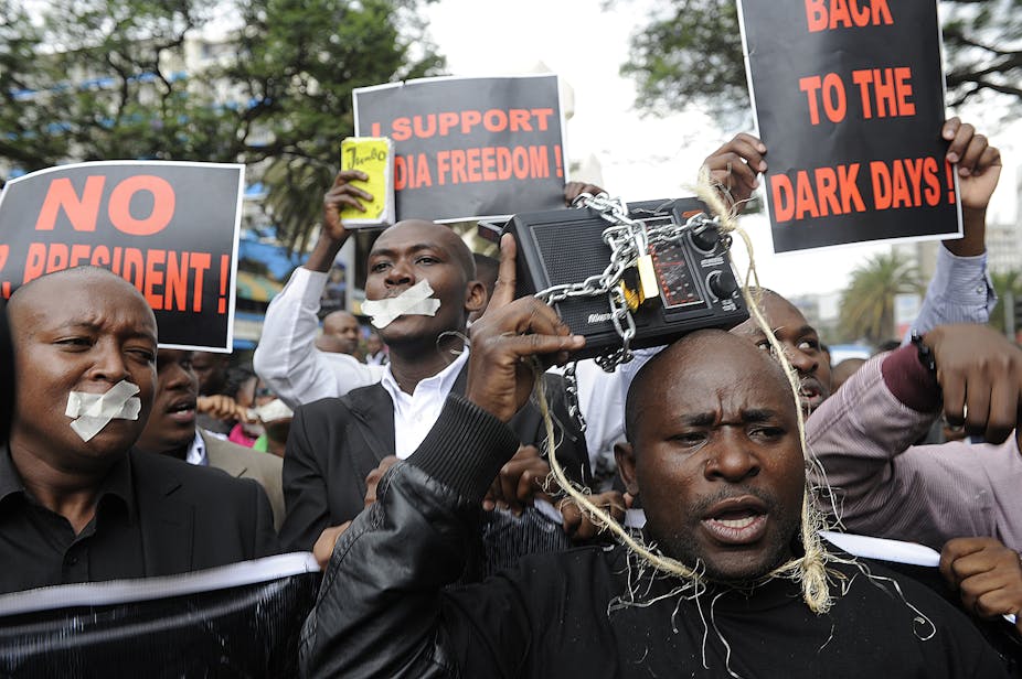 Kenyan journalists, some covering their mouths with tape, hold signs during a protest against a controversial bill that they say would allow the government greater control over the press in Nairobi on December 3, 2013. If passed, the bill would give the government greater freedom to seize journalists' equipment, search their postal mail and impose hefty fines to media houses and journalists.