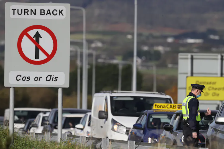 Cars queue at a sign that says