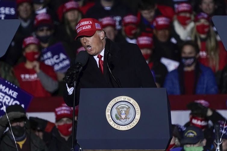 Donald Trump speaks into a microphone.