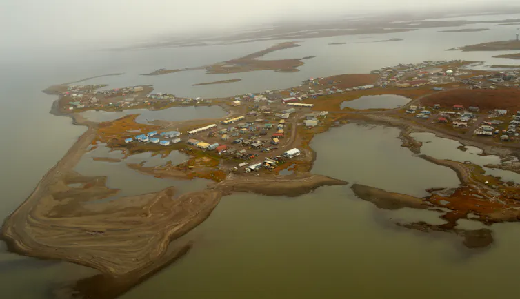 Aerial view of a low-lying coastal town built on permafrost.