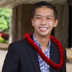 Headshot of Tam wearing a red lei