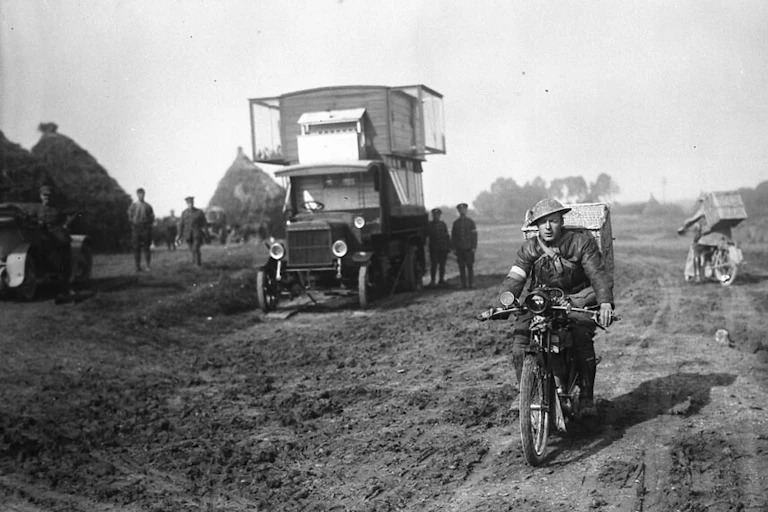 A man on bicycle watched by still soldiers.