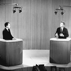 Richard Nixon and John F. Kennedy are seen debating in television studio.