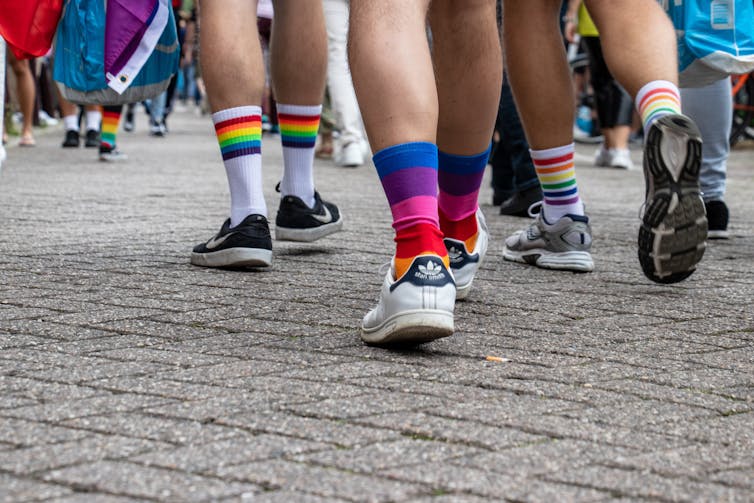 Three people walking in queer socks