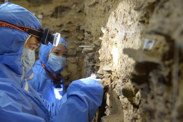 Archaeologists dig in cave walls.