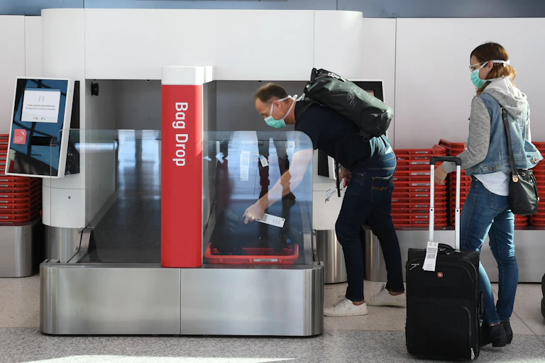 A man loads luggage onto a bag drop at Sydney airport.