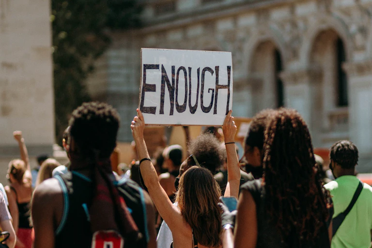 Protestors. A sign reads 'enough'.