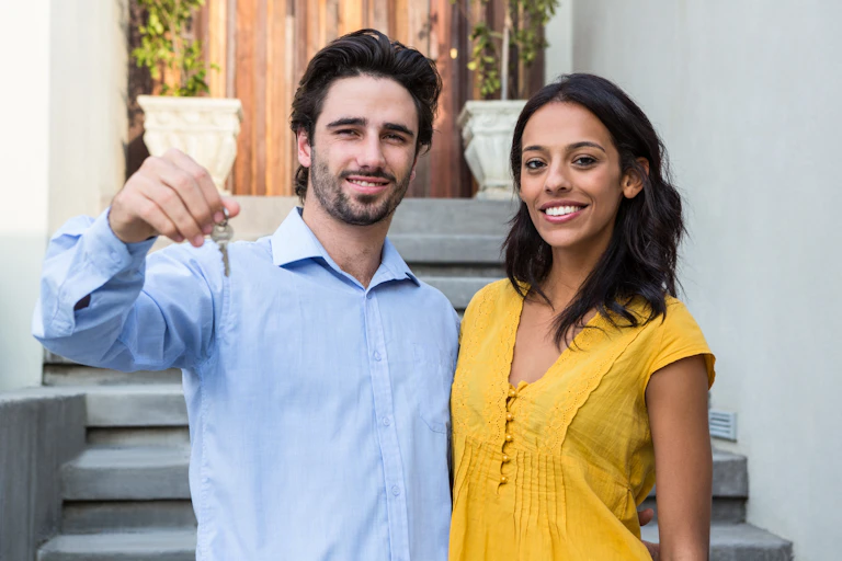 Couple in front of house with key