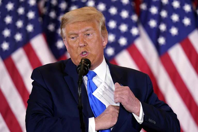Donald Trump with a US flag behind him.