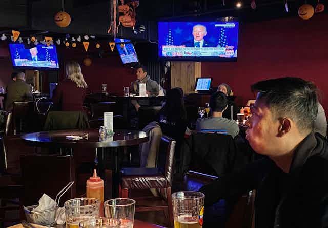 Customers watch the election might coverage at a bar in Beijing.