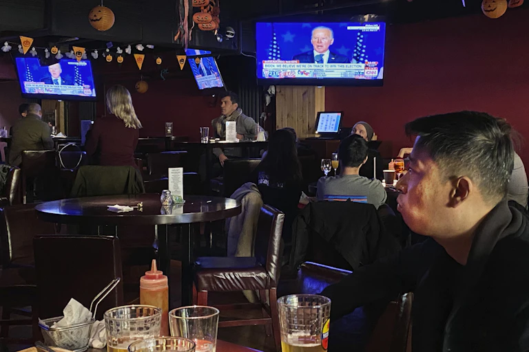 Customers watch the election might coverage at a bar in Beijing.