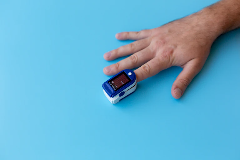Pulse oximeter on a man's index finger.
