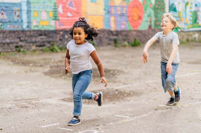 Two children running on street