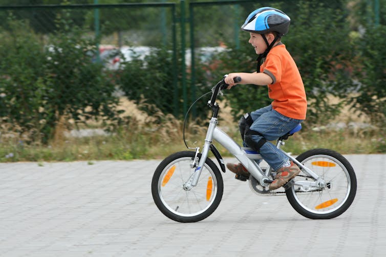 Boy cycling on paved street