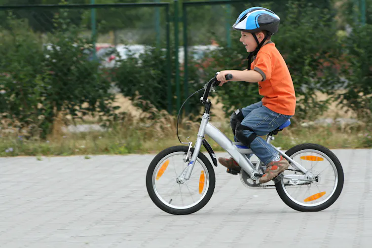 Boy cycling on paved street