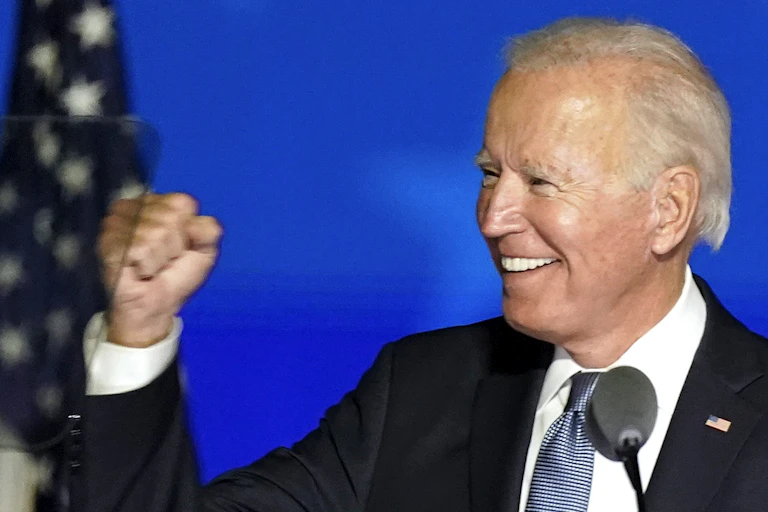 Donald Trump and Joe Biden each hold up their fists during appearances on election night.