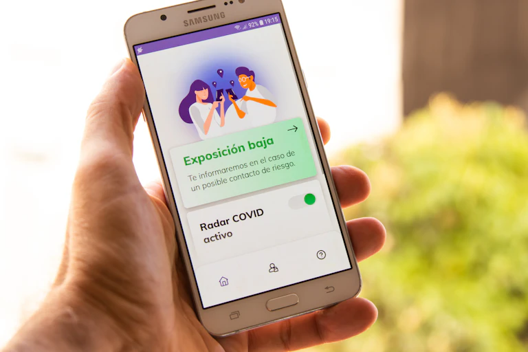 mano con yeléfono móvil con la aplicación Radar Covid abierta.