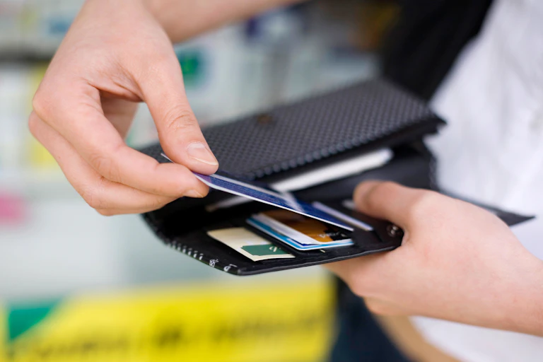 man's hand pulls out card from wallet
