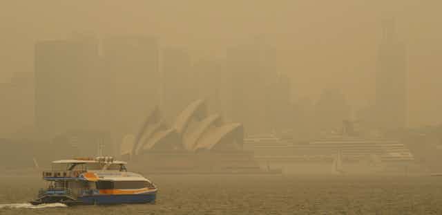 A ferry in Sydney Harbour blanketed in smoke.