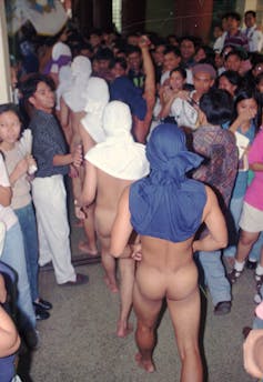 Students parade naked during a hazing ritual