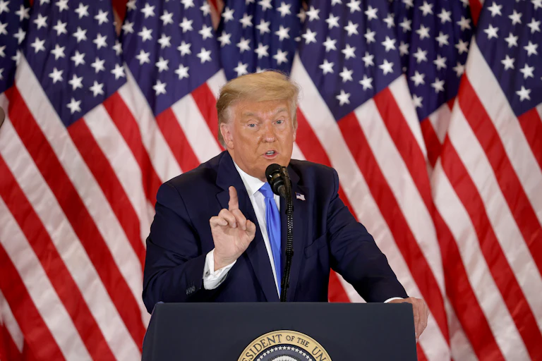 Donal Trump in front of American flags