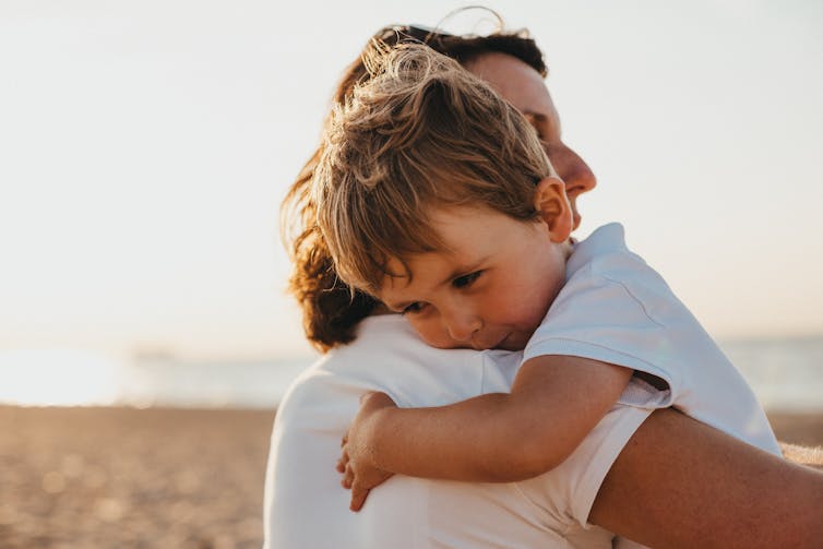 A mother hugs a young boy.