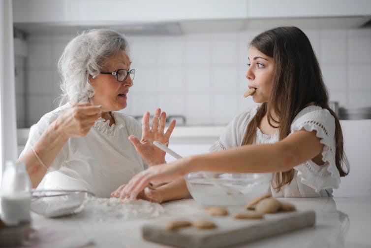 Grandmother and granddaughter having a conversation while baking.