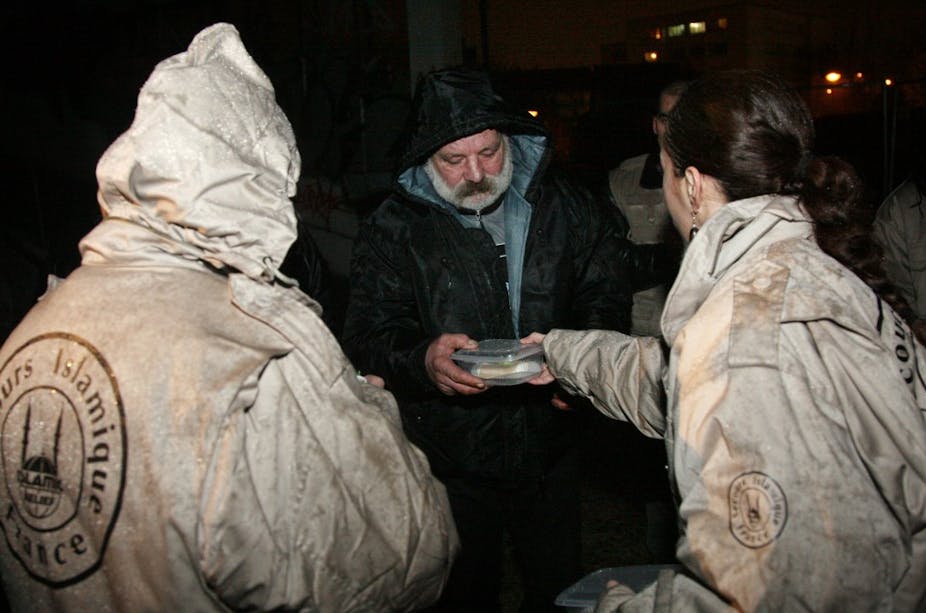 Des membres du Secours islamique de France distribuent une part de bûche et des kit d'hygiène à des sans abris, Noël 2009