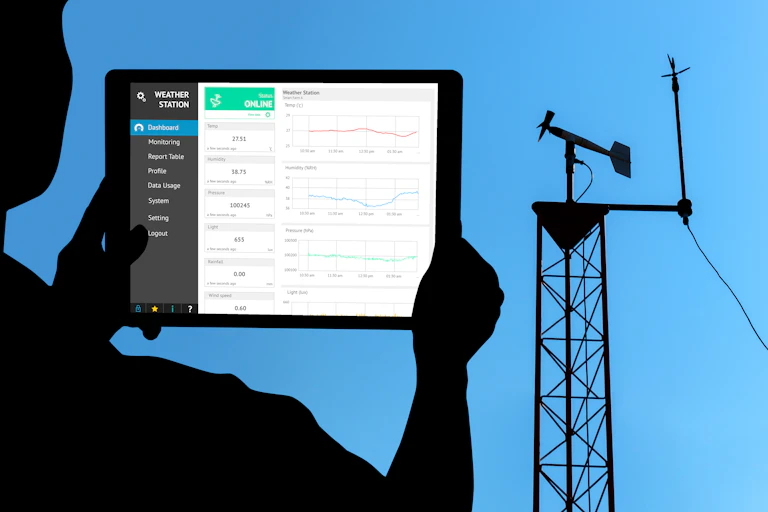 Frente a una torre meteorológica, un operario mira en una tableta datos
