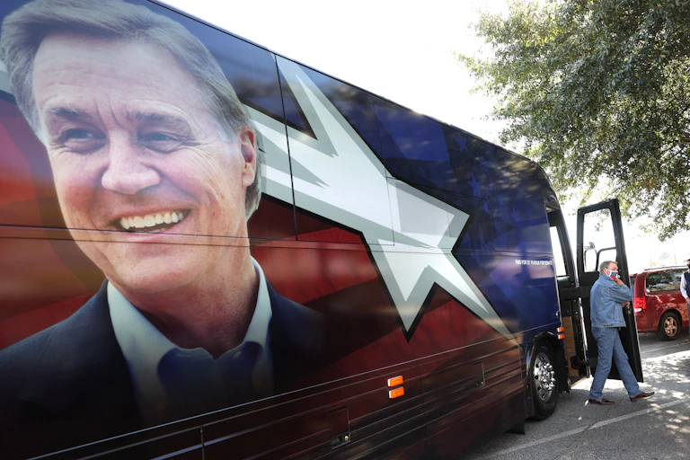 Senator David Perdue walks off of his campaign bus.