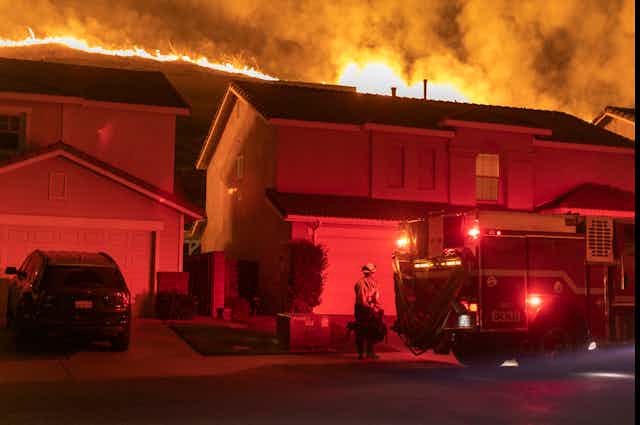 Fire burns on ridge behind homes