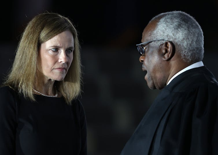 Judge Amy Coney Barrett talks with Supreme Court Associate Justice Clarence Thomas during her ceremonial swearing-in ceremony to be U.S. Supreme Court.