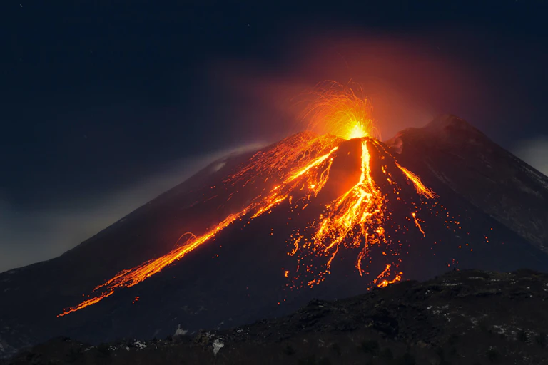 Gunung berapi erupsi saat malam, aliran lava.