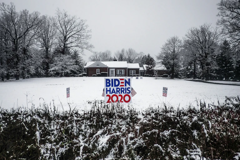 A sign for Biden and Harris in a snowy field.
