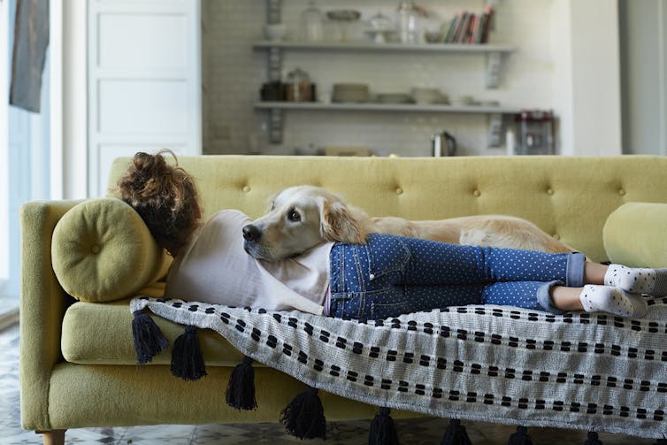 woman lying on couch with dog