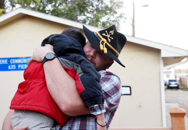 A veteran hugging his young son.